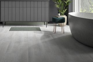 modern grey bathroom with curved stone bath and grey stone flooring